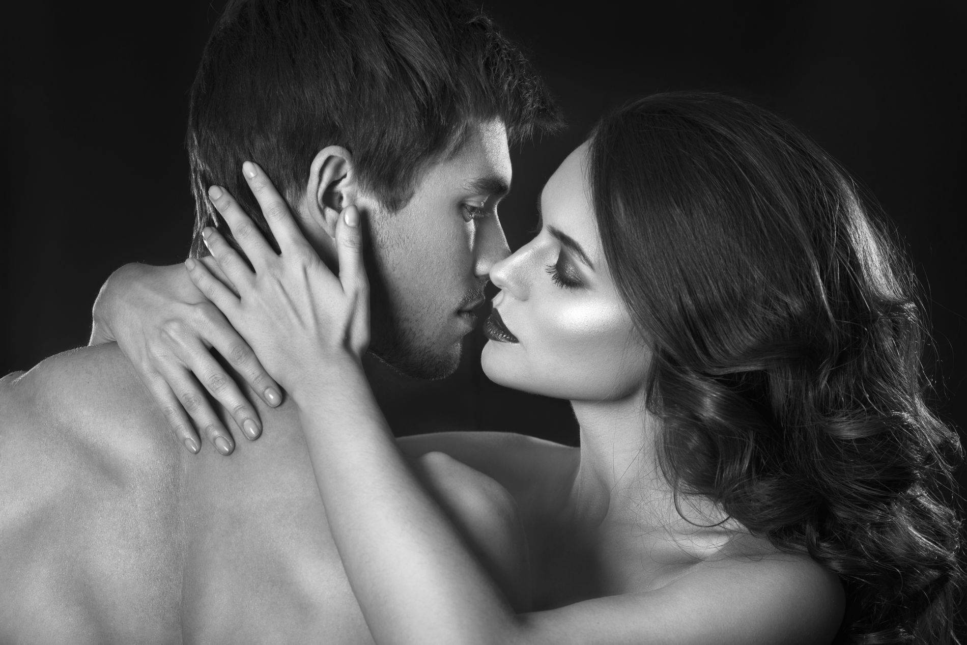 Woman and man about to kiss. The woman is a cuckoldress: She is about to kiss her lover and is confident about it.
